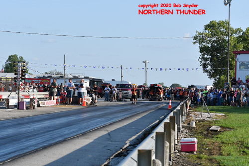 Track crew and racers standing for the national anthem